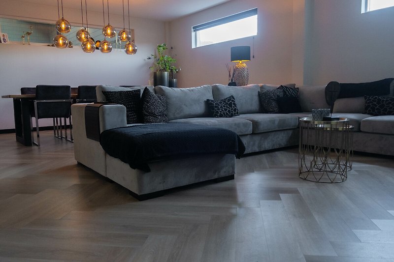Gemütliches Wohnzimmer mit Holzboden, bequemer Couch und stilvoller Einrichtung.