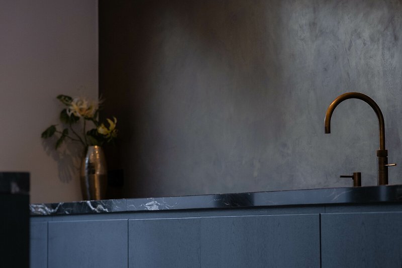 Moderne Küche mit grauen Schränken, Holzoberflächen und stilvollem Design.