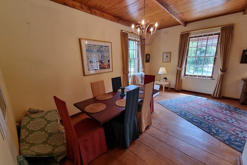 Esszimmer mit Holzboden in anschluss zur Küche, Wohnzimmer und Garten.
