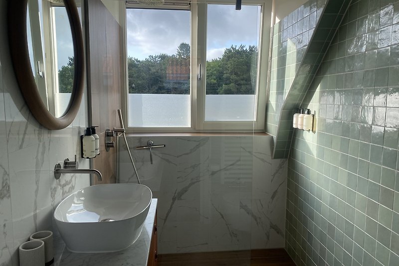 Een moderne badkamer met een wastafel, spiegel en kraan.