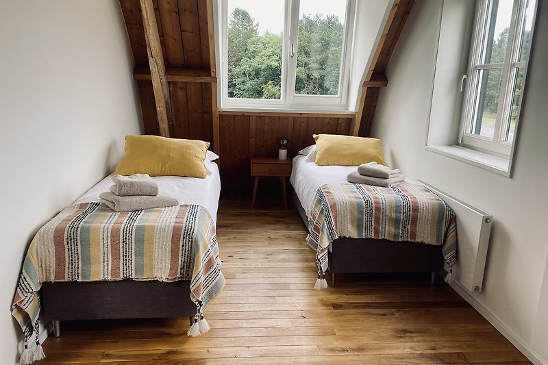 Een comfortabele slaapkamer met een houten bedframe en zachte beddengoed.