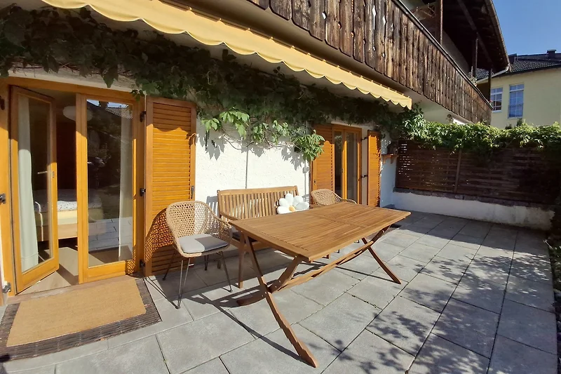 Terrasse mit gemütlicher Sitzgelegenheit und eingezäuntem Garten