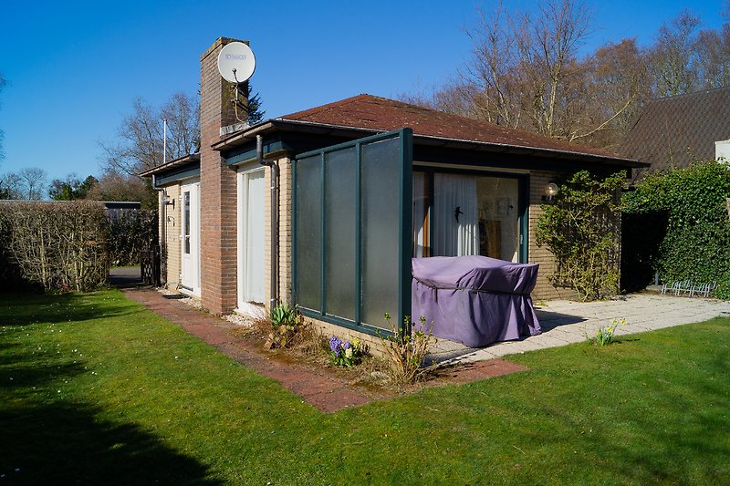 Einladender Garten mit gepflegtem Rasen und schattigem Sitzbereich.