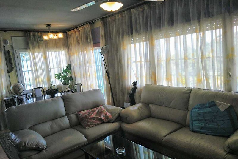 Hermoso salón con muebles, cortinas y lámpara.