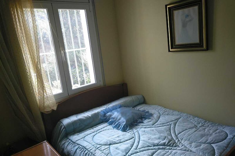 Hermosa habitación con ventana, cama cómoda y cortina.