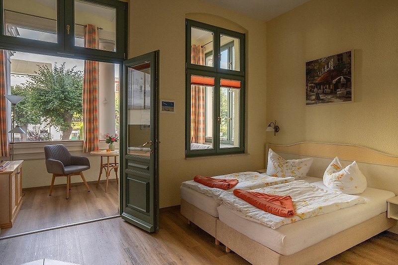 Ein komfortables Schlafzimmer mit Holzmöbeln und großen Fenstern.