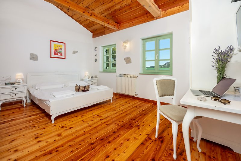 Gemütliches Wohnzimmer mit Holzmöbeln, stilvoller Einrichtung und Laptop.
