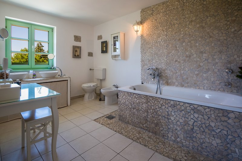 Master Suite bathroom with tub, 2 sinks, toilet, bidet, cosmetic desk and all bath toiletries