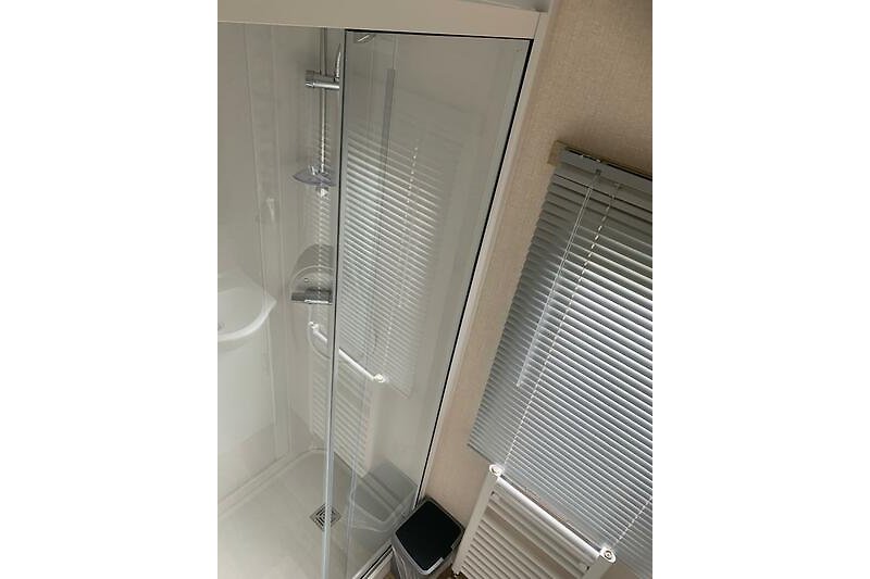 Badkamer voorzien van douche met schuifwand en douchemengkraan
