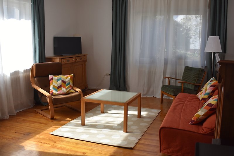 Wohnbereich mit Couch, Sesseln und TV-Gerät