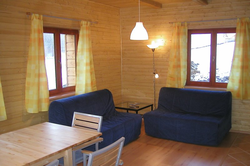Wohnzimmer mit Holzmöbeln, Tisch, Couch und Lampe.