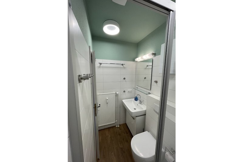 Modernes Badezimmer mit Aluminium-Spüle, Glasfenster und Metallarmatur.