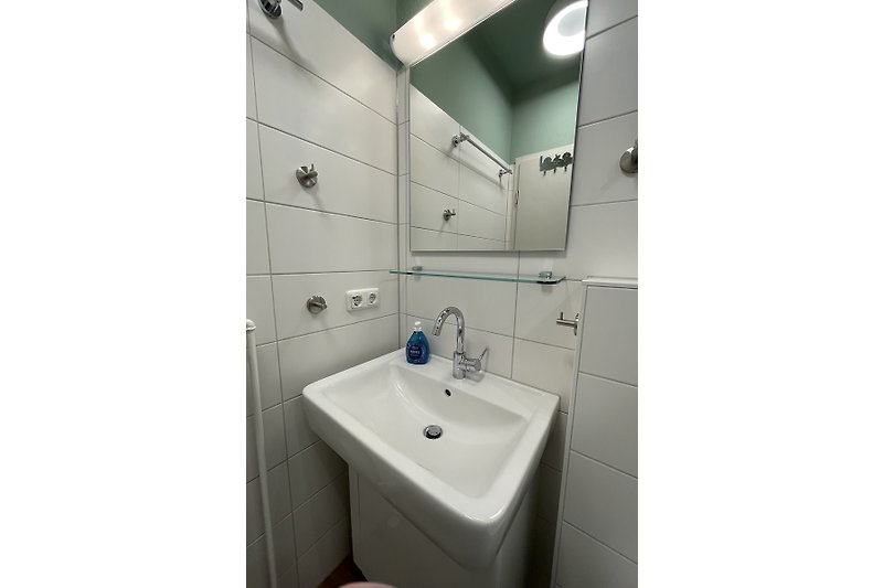 Modernes Badezimmer mit Glasdusche, Spiegel und Badewanne.