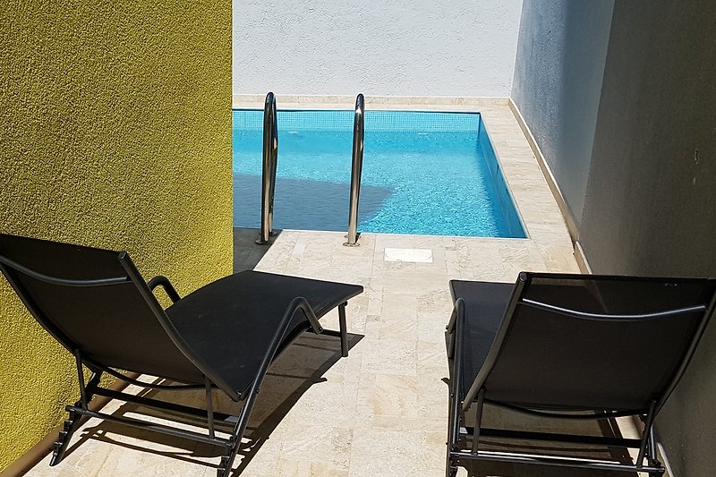 Auf der Sonnenterrasse am Pool bieten vier Sonnenliegen eine erholsame Unterbrechung vom Badevergnügen.