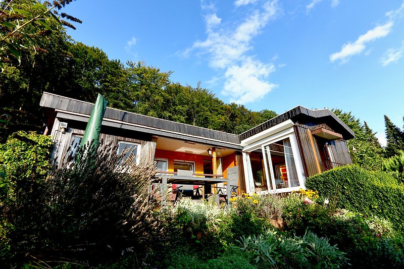 Schönes Ferienhaus mit grünem Garten und malerischer Landschaft.
