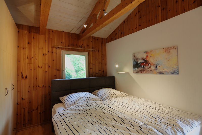 Schlafzimmer 2 mit Kingsize Bett (180x200 cm) u. Einbauschränken mit direktem Zugang zum Bad und Wintergarten.