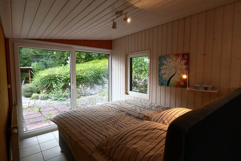 Schlafzimmer 1 mit Kingsize Bett (180x200 cm) und Einbauschränken. Direkter Zugang zur West-Terrasse. Elektr. Jalousie.