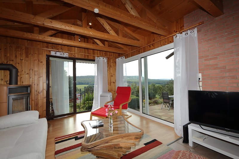 Gemütliches Wohnzimmer mit Holzmöbeln, Fenster und bequemer Couch.