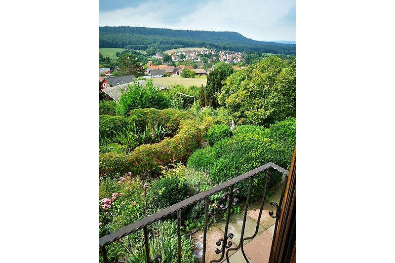 Schönes Ferienhaus mit grünem Garten, malerischer Landschaft und blühenden Pflanzen.