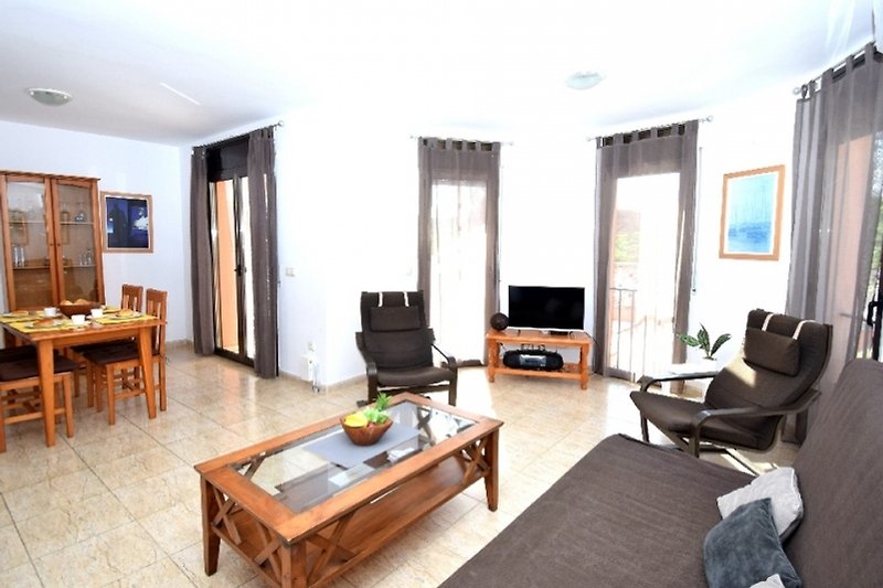 Gemütliches Wohnzimmer mit Holzmöbeln, bequemer Couch und stilvoller Beleuchtung.