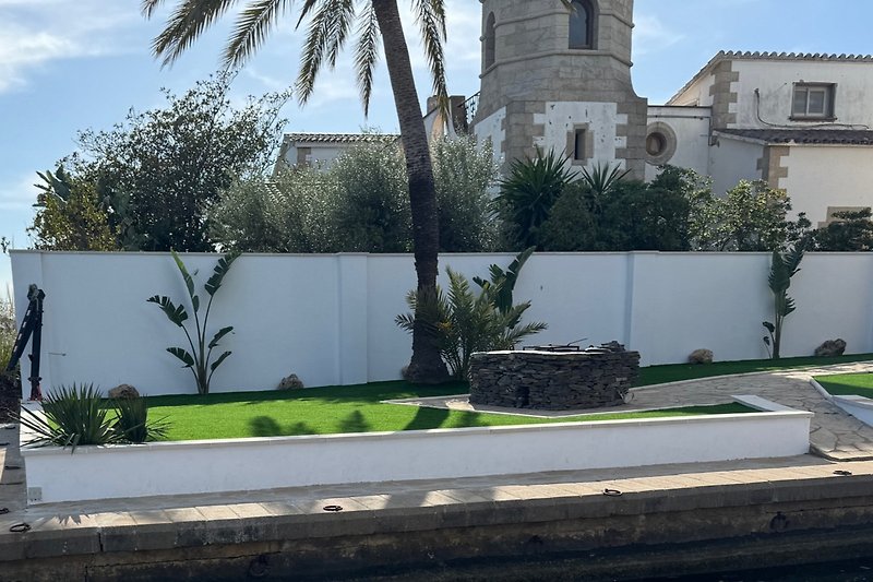 Elegantes Haus mit Palmen und gepflegtem Garten.
