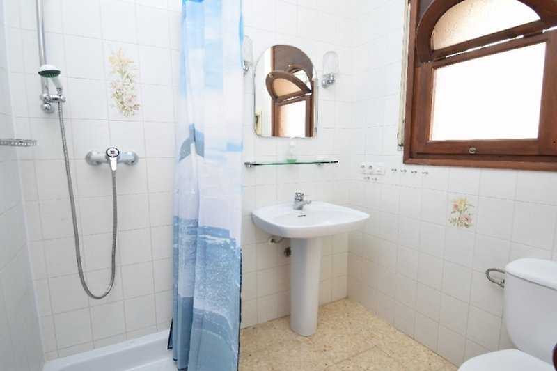 Spiegel, Wasserhahn, Waschbecken und Architektur in einem lila Badezimmer.