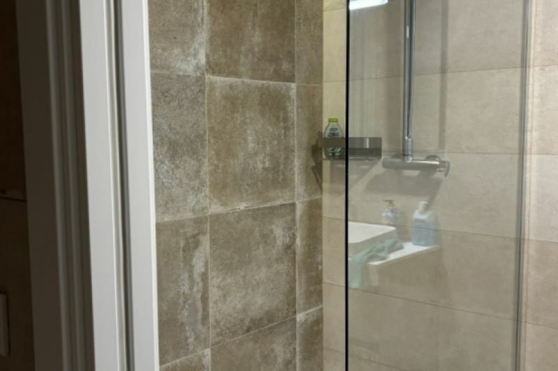 Modernes Badezimmer mit Dusche und Fenster.