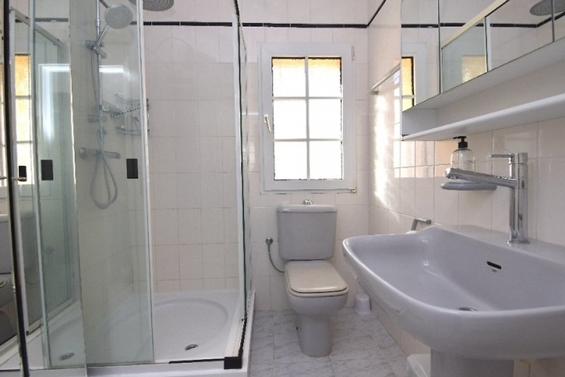 Modernes Badezimmer mit Badewanne, Dusche und stilvollen Armaturen.
