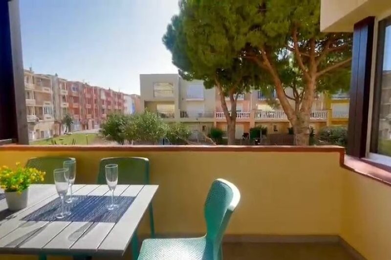 Balkon mit Holzmöbeln und Pflanzen im Innenhof.