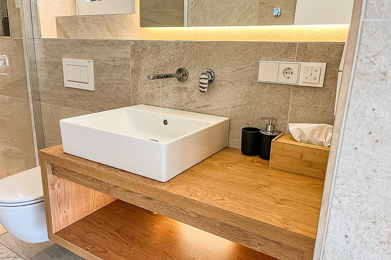 Schönes Badezimmer mit Badewanne, Holzboden und Marmorfliesen.