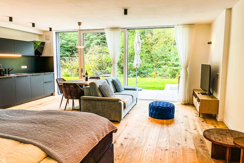 Gemütliches Wohnzimmer mit bequemer Couch, Holzmöbeln und Pflanzen.