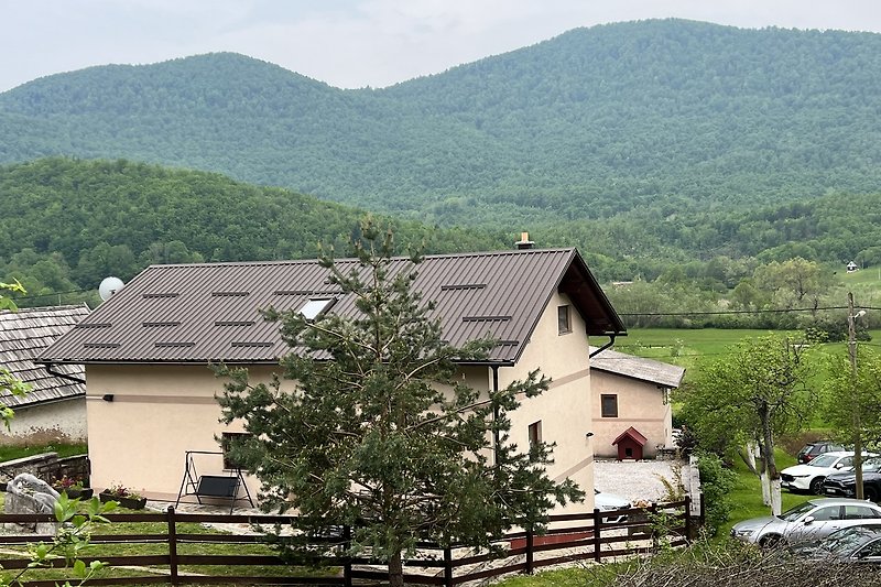 Planinska kuća s pogledom na planine, kuća, prirodni krajolik i drveće.