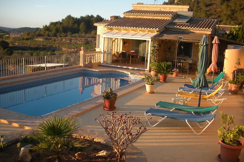 Pool, Terrasse und Haus mit Wintergarten