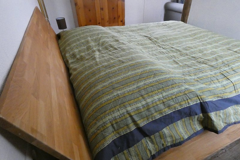 Gemütliches Schlafzimmer mit Holzbett, kreativer Kunst und gemütlicher Bettwäsche.