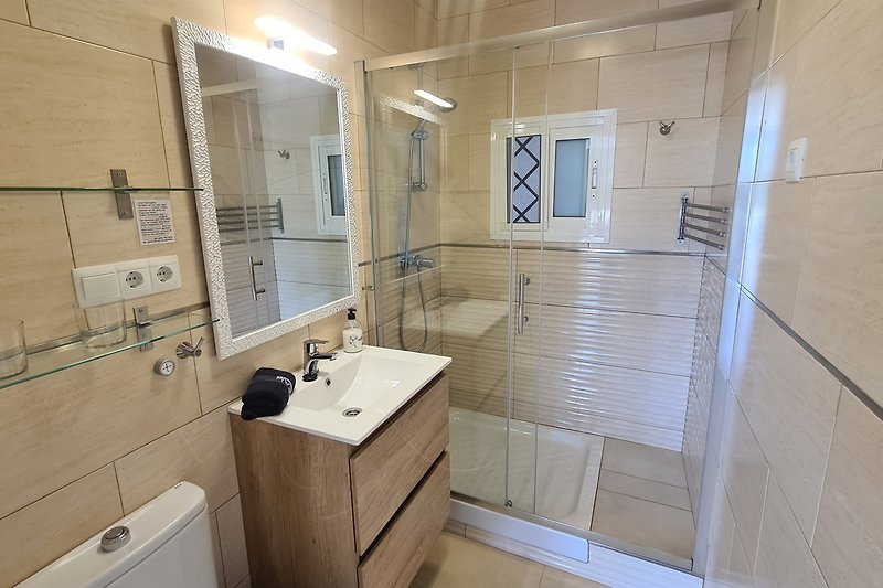 Bad mit gr. Dusche, Echtglas-Duschwand, modernem Badmöbel und vielen Haken und Stangen sowie Fenster mit Fliegengitter