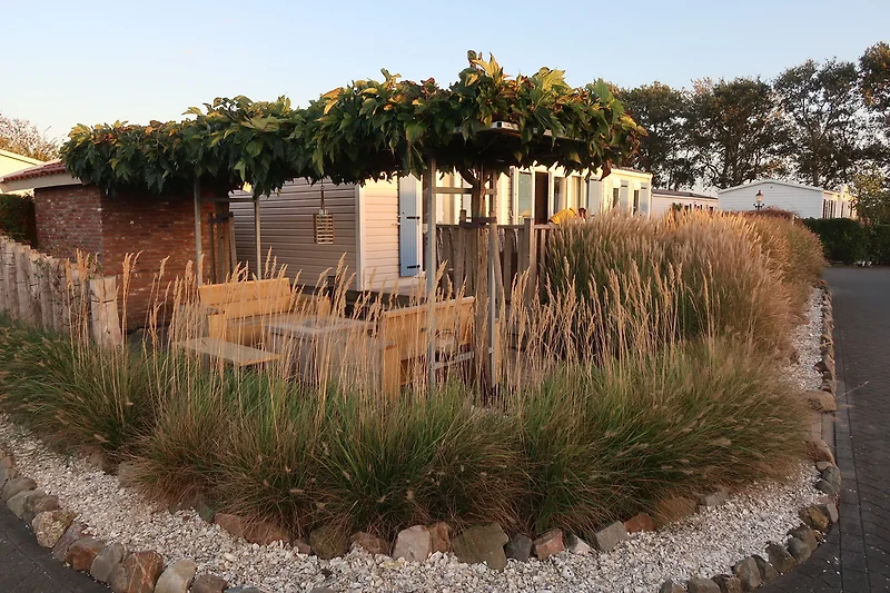 Gepflegter Garten mit Hecke, Einfahrt, Weg und Zaun im Hinterhof.