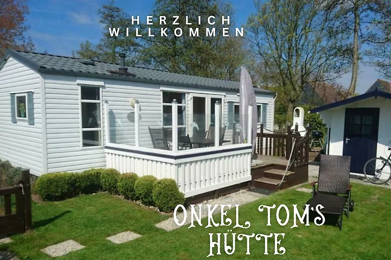 Ferienhaus mit Veranda, Rasenfläche und großzügigem Holzdeck.