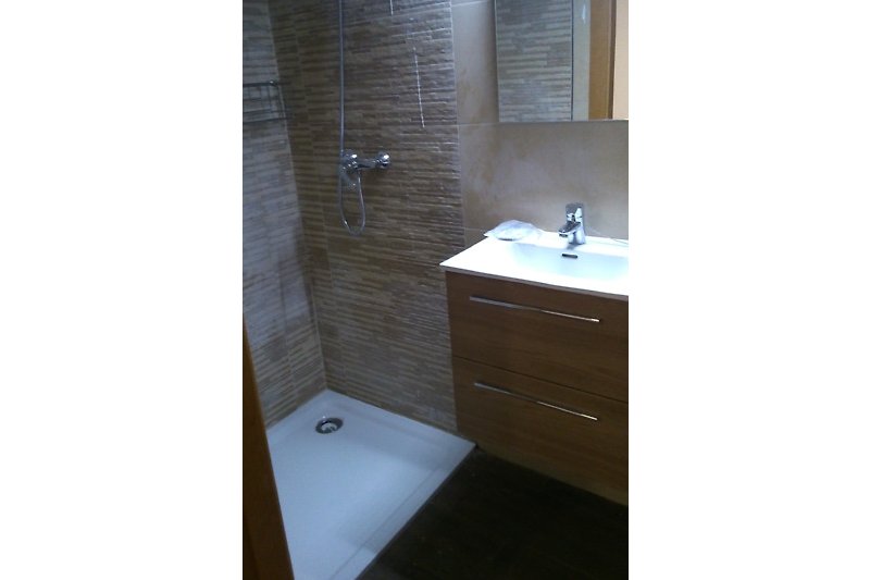 Modernes Badezimmer mit Spiegel, Waschbecken und Schrank.