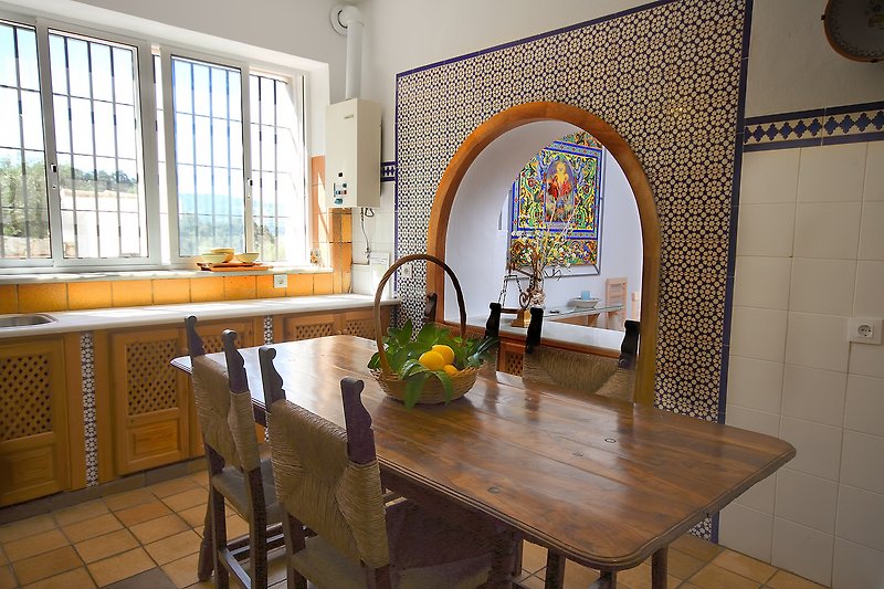 Mesa rústica que se centra en la cocina y permite su uso para cocinar o para comer. Conexion con salon comedor.