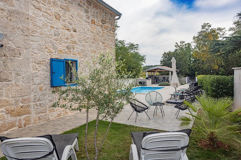 Schönes Ferienhaus mit Pool, Garten und stilvoller Außenmöblierung.