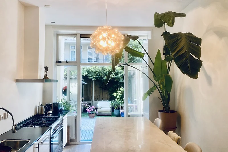 Open keuken met marmeren kookeiland en bar.