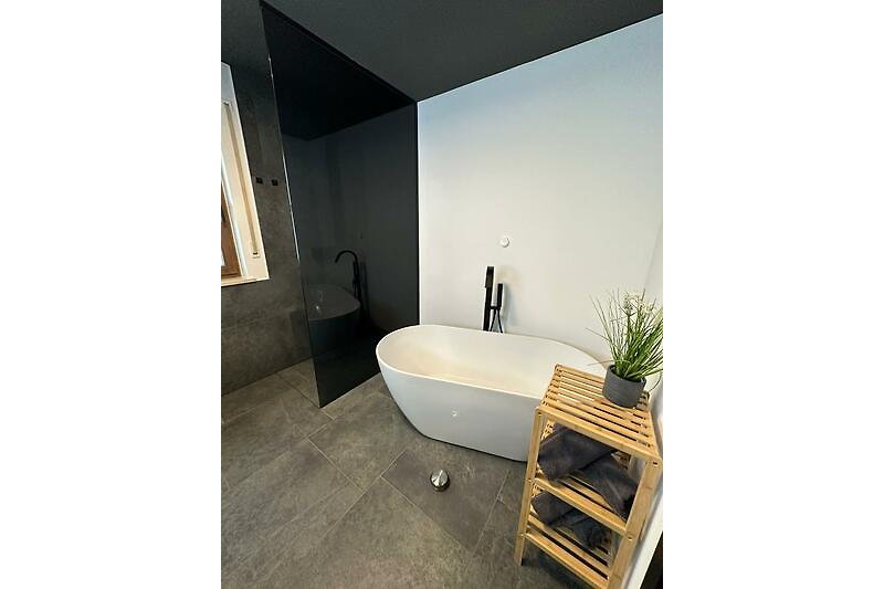 Ein stilvolles Badezimmer mit Badewanne, Pflanzen und elegantem Design.