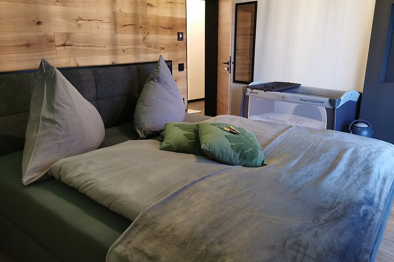 Gemütliches Schlafzimmer mit bequemem Bett und stilvollem Holzbettgestell.