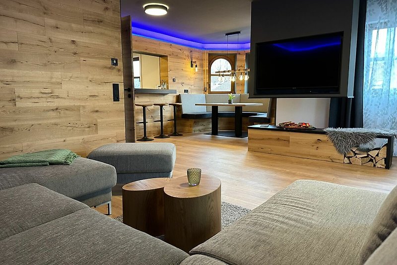 Stilvolles Wohnzimmer mit Holzboden, bequemer Couch und stilvoller Inneneinrichtung.