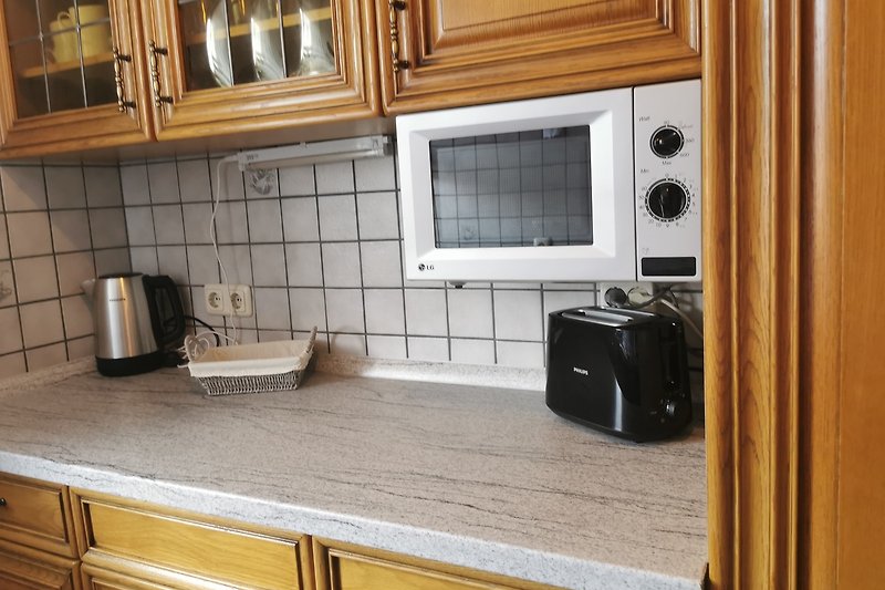 Stillvolle Küche mit Mikrowelle, Wasserkocher und Toaster.