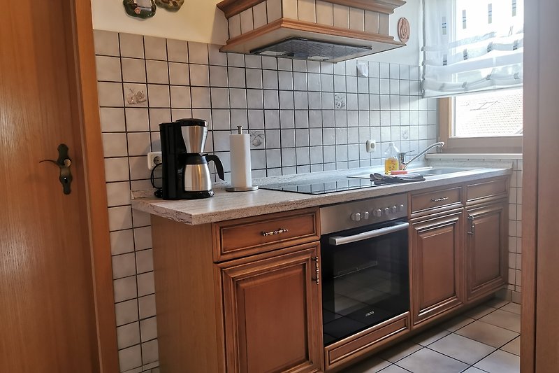 Stillvolle Küche mit Spüle, Geschirrspülmaschine und Kaffeemaschine.