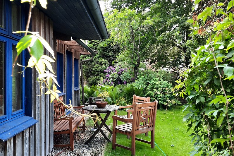 Einladender Garten mit gemütlicher Außenmöblierung und schattigem Platz.