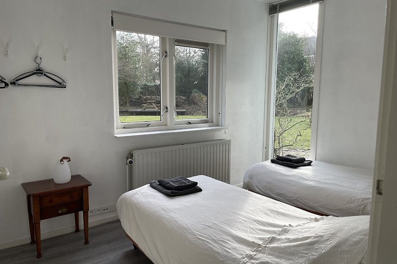 Gemütliches Schlafzimmer mit stilvoller Einrichtung und Fensterdekoration.