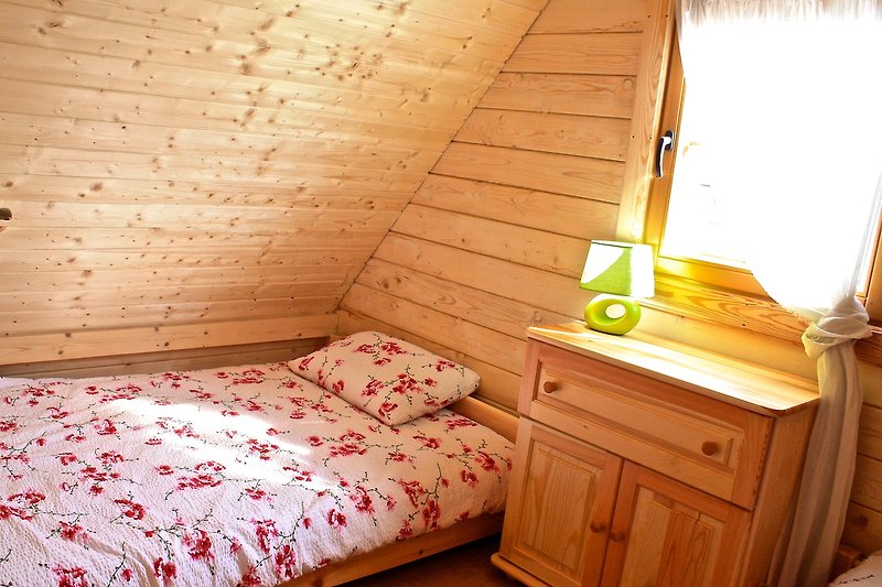 Komfortowe drewniane meble w sypialni z pięknym widokiem przez okno.