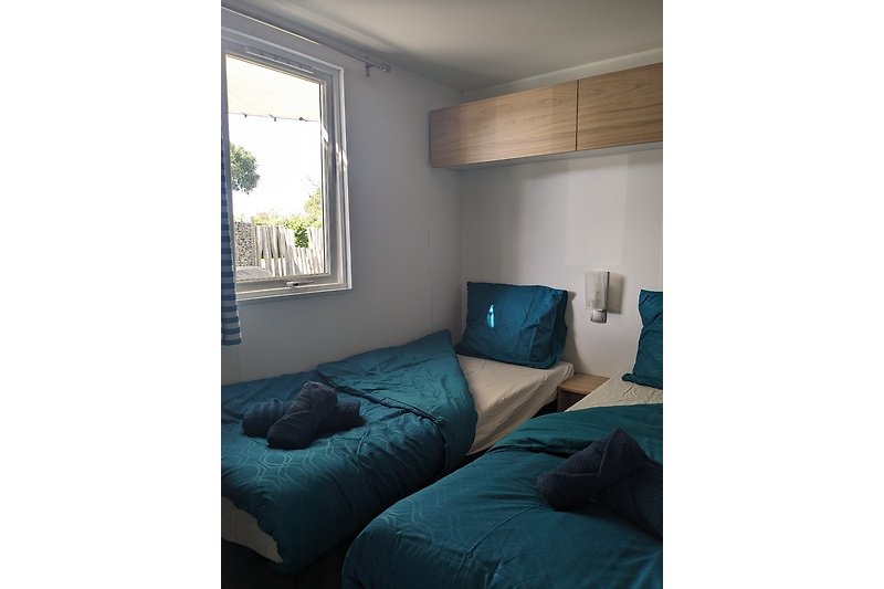 Ein komfortables Zimmer mit blauem Holzboden und gemütlichem Bett.